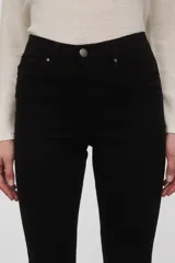 Pantalon de jean negro, corte skinny y tiro medio, con cierre frontal y bolsillos laterales.