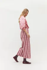 Pantalón de jean de corte recto y tiro alto con estampado de rayas verticales en tonos rosados. Cuenta con cierre frontal y bolsillos laterales.
