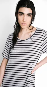 Vestido largo de corte recto, con cuello bote, mangas cortas y abertura lateral. Diseño a rayas horizontales en blanco y negro. Incluye lazo en la cintura.