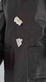 Blazer de cuero dorado metalizado, con bolsillos frontales aplicados, solapas clásicas y cierre con grandes botones de nácar.