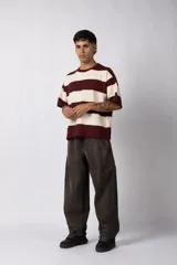 Remera de tejido de punto con diseño de rayas horizontales anchas en color bordó y crema, de corte oversize y cuello redondo.