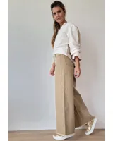 Pantalón de jean color beige, de corte recto y tiro alto, con ruedo deshilachado y cierre frontal con botón y cremallera.