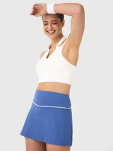 Top blanco con diseño cuello polo, corte cropped, sin mangas y espalda deportiva. Ideal para jugar pádel o tenis.