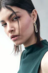 Aros colgantes dorados formados por dos eslabones rectangulares unidos.