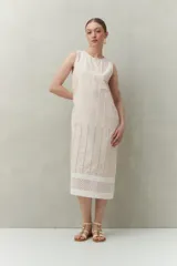 Vestido largo blanco de algodón con calados verticales y bordado tipo ojo de perdiz, sin mangas y de silueta recta.