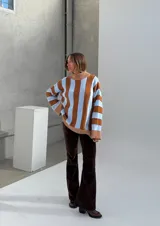 Sweater de punto con cuello alto, a rayas verticales anchas color celeste y marrón, con detalles de lurex en las rayas finas color marrón.