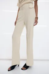 Pantalón de vestir de tiro bajo con corte flare y línea evasé. Confeccionado en mezcla de viscosa, presenta cintura con trabillas, bolsillos delanteros con solapa, bolsillos laterales ocultos y bolsillos de vivo en la parte trasera. Incluye detalle de raya planchada y cierre frontal con cremallera, botón y ganchos metálicos.