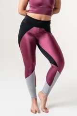 Calza deportiva tiro alto con faja doble tela, elástico en cintura y diseño color block en negro, magenta y gris.