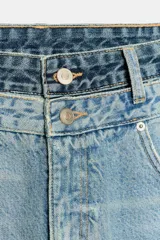 Bermudas de denim de tiro medio y calce regular, con diseño de cinco bolsillos. Presenta detalle de doble cintura con doble botonadura y rotos en la parte delantera. Cierre frontal con cremallera y botones metálicos.