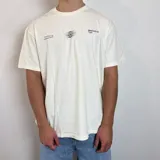Remera negra de corte regular con estampa gráfica en la espalda que incluye un diseño circular abstracto y el texto BREATHEfast.