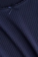 Remera de punto acanalado color azul marino, de corte ajustado y manga larga. Presenta un escote pronunciado con detalle de encaje en el borde y una pequeña moña de satén en el centro.