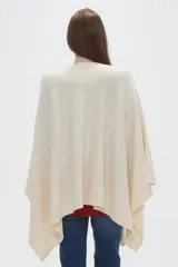 Poncho crudo de tejido de punto con diseño holgado y sin mangas.
