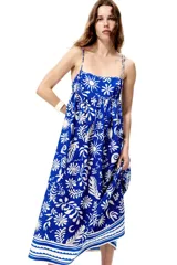 Vestido midi en mezcla de viscosa, de color azul con estampado botánico en tono blanco. Presenta breteles spaghetti con moños para atar, escote cuadrado, canesú ajustado con punto smock en la espalda y falda larga y fruncida con diseño de guardas en el ruedo.