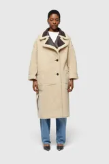 Abrigo largo reversible de ecopiel de oveja color azul con detalles en piel sintética.