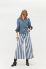 Pantalón de corte ancho y tiro alto con estampado de rayas verticales en tonos azul y blanco. Confeccionado en algodón, presenta un diseño de pierna recta y holgada.