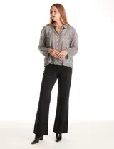 Camisa de algodón color gris con bordados florales en el frente y las mangas. Tiene cuello con solapa y cierre frontal con botones.