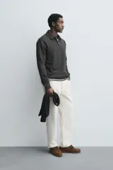 Polo de manga larga color gris oscuro, con diseño de textura estructurada, cuello solapa y cierre frontal de cremallera corta. Cuenta con puños y cintura de rib elástico.