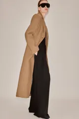 Abrigo largo entallado de Zara Woman Collection, confeccionado en mezcla de lana color tostado. Presenta cuello con solapa de muesca, mangas largas, bolsillos con solapa en el frente, forro interior y cierre frontal de dos botones oscuros.