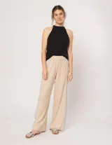 Pantalón palazzo color beige con cintura elastizada y dos franjas verticales en los laterales, una plateada y otra blanca.