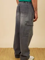 Pantalón cargo de jean con efecto lavado, corte recto y holgado. Cuenta con cintura elástica con cordón de ajuste y bolsillos laterales tipo cargo con solapa.