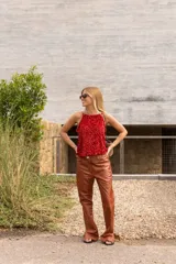 Pantalón de cuero color marrón, de tiro alto y corte recto con leve ensanchamiento en el bajo. Presenta un forro interior suave.