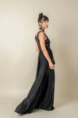 Vestido largo rojo con cuerpo de lentejuelas y falda de satén con caída fluida. Presenta escote redondo, sin mangas y un lazo en la cintura.