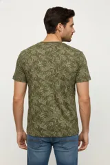Remera de manga corta con cuello redondo, confeccionada en algodón con estampado botánico de hojas en tonos verdes.