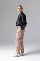 Chaqueta bomber negra con cierre frontal de botones a presión y bolsillos laterales.