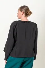 Chaqueta negra de crepe con solapas y borde frontal con lentejuelas. Corte recto y mangas largas.