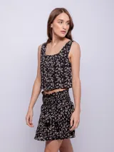 Minifalda negra con estampado de pequeñas flores, diseño de capas con volados y cintura elástica fruncida.