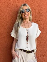 Blusa color beige de seda opaca, con cuello redondo y mangas cortas.