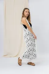 Chaleco largo tejido en punto calado color beige, de silueta recta y caída fluida. Presenta un diseño artesanal con transparencias sutiles que aportan textura y movimiento.