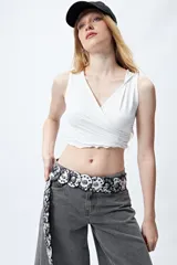 Top cropped negro con capucha, escote cruzado y calce ceñido.