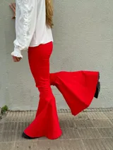 Pantalón negro de tiro alto con corte acampanado y terminación en volado en el ruedo.