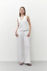 Pantalón blanco de lino, de corte ancho y con tajo lateral en el ruedo.