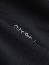 Conjunto de pijama Calvin Klein compuesto por una remera negra de algodón con cuello redondo y mangas cortas, y un short azul estampado con cintura elástica con el logo de la marca.