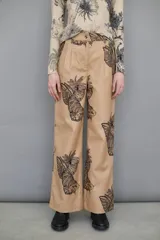 Pantalón de paño de lana color beige con estampado Toile de Jouy, corte recto y bolsillos delanteros.