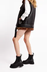 Botas Chelsea negras de cuero vacuno con elásticos laterales, caña media y suela track.