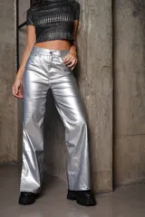 Pantalón plateado metalizado elastizado de ecocuero, con corte recto, tiro alto, cierre frontal con botón y bolsillos traseros.