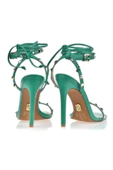 Sandalias de tacón alto color verde con tiras finas y apliques de tachas doradas.