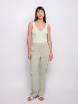 Pantalón cargo de tiro alto, color verde claro, con corte recto y ancho. Presenta bolsillos cargo laterales, costuras marcadas en el frente y elástico en la parte trasera de la cintura.