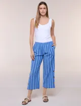 Pantalón de algodón rústico color verde, de tiro medio-alto con pretina elastizada y bolsillos laterales. Presenta corte holgado, diseño cropped de pierna ancha y aberturas laterales en los tobillos con detalles de botones.