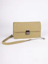 Bandolera rectangular color verde oliva, de símil cuero, con correa fija de cuero y cadena metálica. Tiene detalle de tachas plateadas en la solapa y broche a presión metálico.