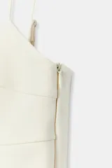Top negro de escote en pico con tirantes finos ajustables, diseño entallado y cierre lateral con cremallera.