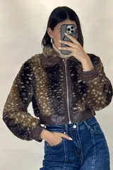 Campera corta de piel sintética con estampado animal print tipo ciervo, cuello clásico, cierre frontal y puños elásticos en cuero sintético.