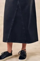 Falda midi de denim color gris oscuro, con diseño asimétrico y bolsillos delanteros.