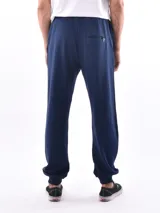 Pantalón deportivo negro, tipo jogging, con cordón ajustable en la cintura y puños elásticos en los tobillos.