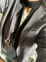 Bufanda de tejido de punto color negro, tipo corbatín.