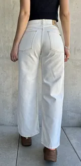 Pantalón jean de tiro alto color blanco, corte recto y pierna ancha.
