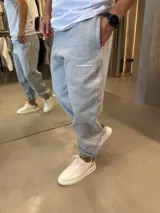 Pantalón de jogging color gris melange, confeccionado en algodón premium, con ajuste de puño en los tobillos, bolsillos laterales y logo pequeño estampado en el muslo.